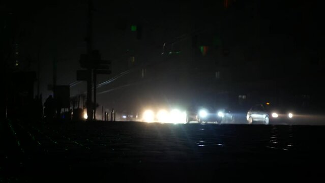 Blackout in the center of Kyiv after the shelling of a critical information structure. The city is completely dark, only the headlights of cars are visible.