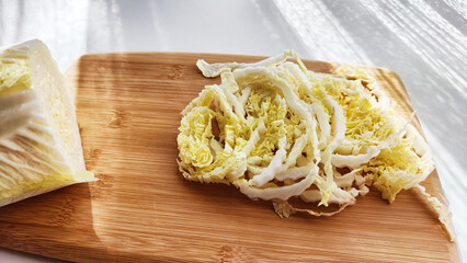 Chopped Peking cabbage on cutting board as a background. Cooking a healthy eco-friendly salad from natural products. Copy space and place for text