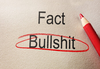 Bullshit circled in red pencil below Fact text, on textured paper