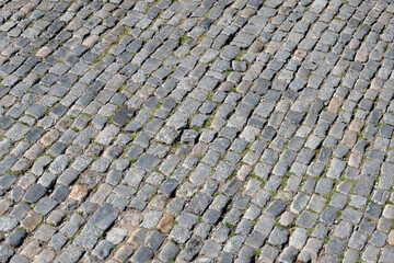 Close-up of an old gray cobbled street.