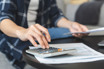Deduction planning concept. Asian young woman hand using calculator to calculating balance prepare tax reduction income, cost budget expenses for pay money form personal Individual Income Tax Return. - obrazy, fototapety, plakaty