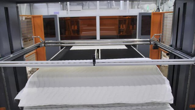 cutting foam rubber for the production. Machine of planimetric cutting of foam rubber, cutting foam rubber, close up of cutting foam, factory for the production of mattresses
