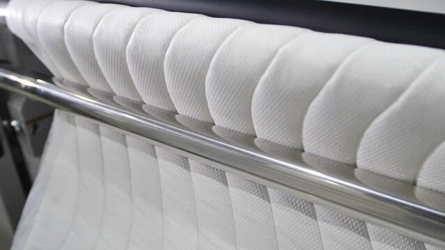 On modern machines manufactured upholstery fabric for furniture. On a large special equipment between the rollers lashed material for lining mattresses.