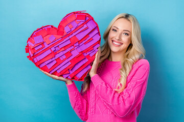 Portrait of adorable positive woman with wavy hairstyle wear pink pullover hold large shape heart box isolated on blue color background
