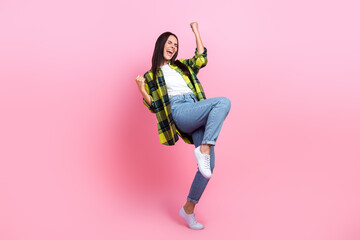 Full length photo of sweet excited woman dressed plaid shirt shouting rising fists isolated pink color background