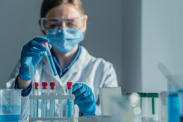 Scientist in biotechnological laboratory is researching new methods treating diseases. Laboratory assistant in a medical laboratory performs blood test to determine level various biological substances - obrazy, fototapety, plakaty
