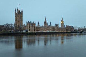 The Westminster Palace and the Big Ben clocktower by the Thames river in London at dawn, United Kingdom