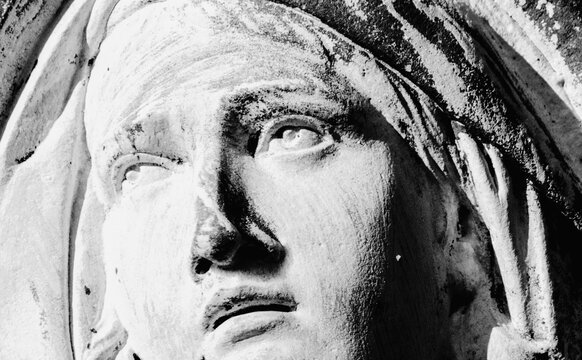 Close up black and white image of fragment of an ancient statue of Virgin Mary as a symbol of love and kindness