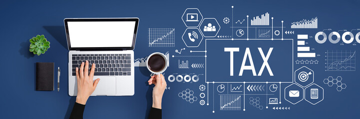Tax theme with person using a laptop computer