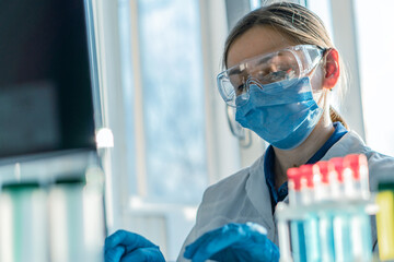 A medical scientist focuses on analyzing data on his computer to develop new drugs and therapeutic methods. A laboratory analyst is doing an experiment in a biotechnology laboratory and analyzing data