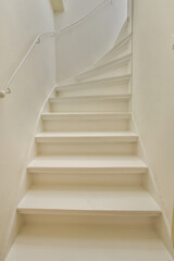 some white stairs in a room with no one person on the stairs, and there is an overhead view of the staircase