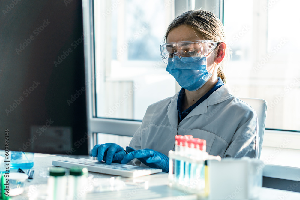 Poster Doctor scientist in biological laboratory analyzes results research on his computer to find new cure. Chemist is engaged in the study of various chemicals in medical laboratory using computer program