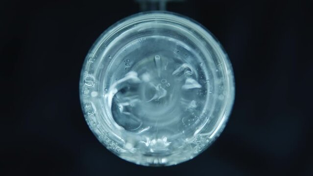 Boiling water in a spherical flask. Dark background. Laboratory equipment. Pharmacology and Medicine. Production of drugs. Extract preparation. 