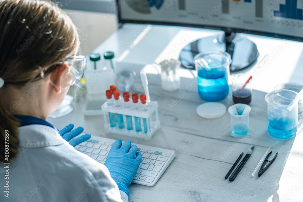 Poster Immunologist reviews data on viral diseases and analyzes them on a computer in laboratory to increase the effectiveness of treatment. A biologist works at a computer in a laboratory and analyzes data