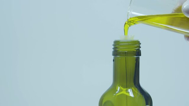 Glass bottle for oil. Cold-pressed. Close-up. Pouring liquid. Extract. Natural antioxidants. Cosmetics. perfume, lab. Cold-pressed oil.