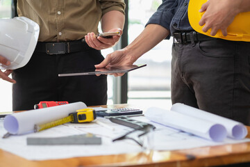 Asian engineers brainstorm and measure to document cost estimates and write floor plans for architectural and engineering designs for houses and buildings.