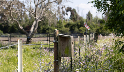 A bird house on a fields fence