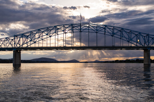 Pioneer Memorial Bridge is seen from the Columbia River with dark clouds at sunset.