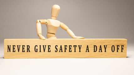Never give safety a day off. Written on wooden surface.