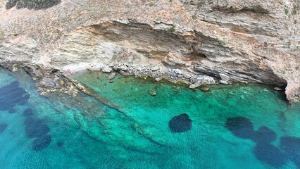 Aerial drone photo of rocky tropical exotic paradise island bay with deep turquoise sea forming a blue lagoon