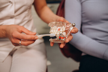 Dentist inserting retainers. Mouthguard with wooden toothbrush in doctors hands in blue gloves, teen orthodontic, Clear Aligner Dental Night Guard oral health care concept.