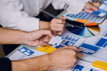 Close up ux developer and ui designer brainstorming about mobile app interface wireframe design on...