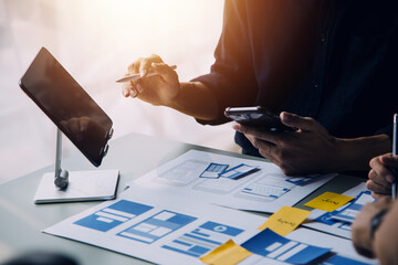 Close up ux developer and ui designer brainstorming about mobile app interface wireframe design on...