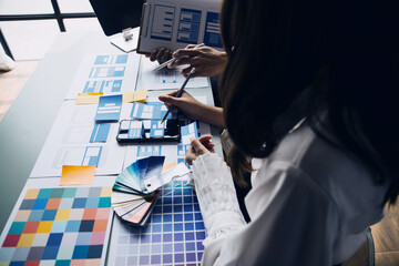 Close up ux developer and ui designer brainstorming about mobile app interface wireframe design on...