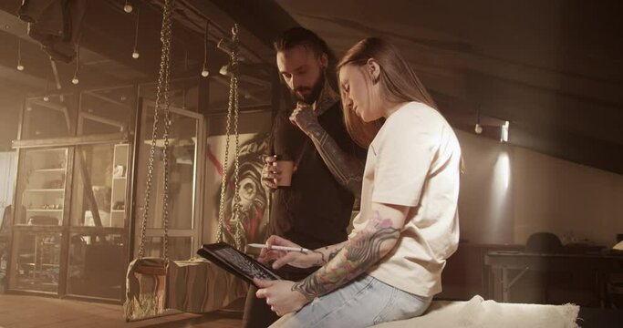Male customer discussing new design with female tattoo artist