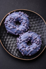 Delicious sweet donut of purple color in glaze and with lilac balls