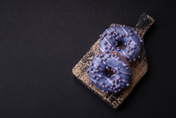 Delicious sweet donut of purple color in glaze and with lilac balls