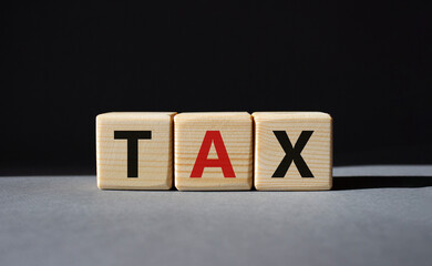 Tax symbol. Wooden cubes with word Tax. Beautiful grey background. Business and Finace and Tax concept. Copy space.