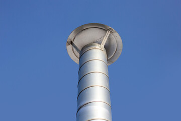 Metal chimney pipe on the roof of house