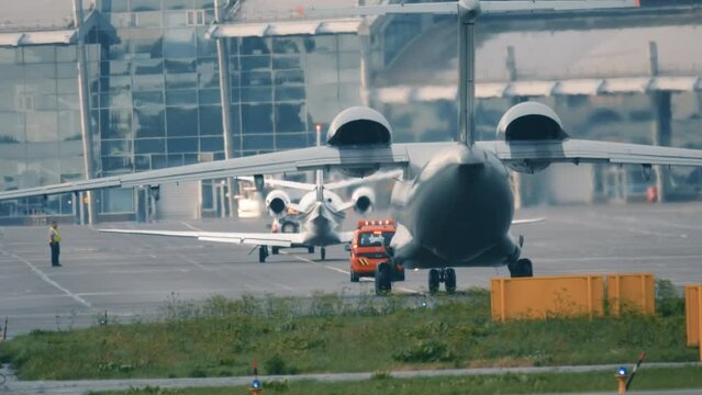 Military aircraft (war plane) is taxiing on the taxiway after landing. Back view