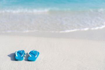 Fototapeta na wymiar Flip flops on the beach on the background of ocean in the Maldives. Beach vacation