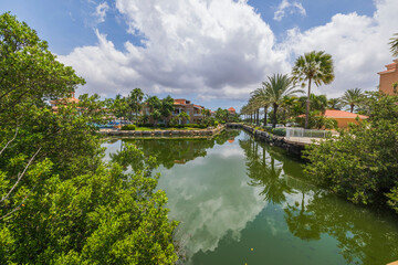 Beautiful view at pond between pink hotel buildings and green plants. Aruba.