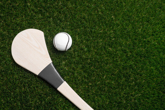 Hurling bat and sloitar on green grass. Horizontal sport theme poster, greeting cards, headers, website and app