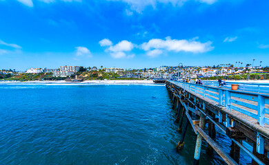 View of San Clemente beach and beachfront housing from the San Clemente Pier in Southern California - obrazy, fototapety, plakaty