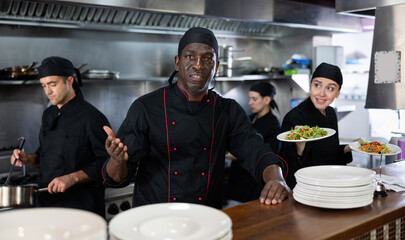 Portrait of confident african american chef and his team in the restaurant kitchen