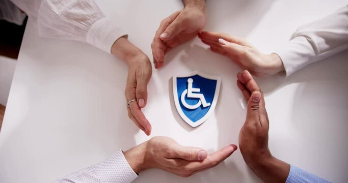 Close-up Of A Hands Protecting Disabled Sign