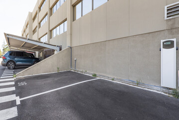 An uncovered parking space with a fast charger for electric vehicles