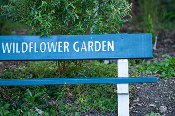 wooden seat, wooden garden sign saying to garden, next to a path in a forest In Australia 