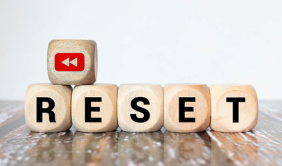 Reset symbol. The concept word 'reset' on wooden cubes. Beautiful white table, white background.