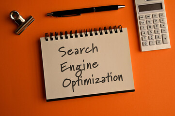 There is notebook with the word Search Engine Optimization. It is as an eye-catching image.