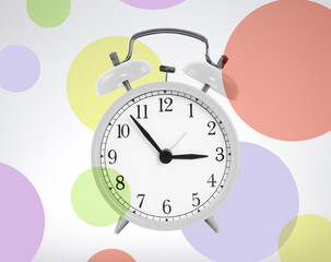 White alarm clock with colored circles in background. fun time concept