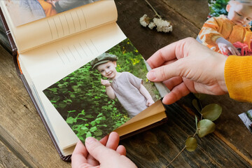 Female hands holds printed photo for family photo album.