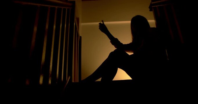 A lonely woman is sitting on the stairs at night . This concept use for symptoms of stress, major depressive disorder (MDD), psychotic symptoms.

