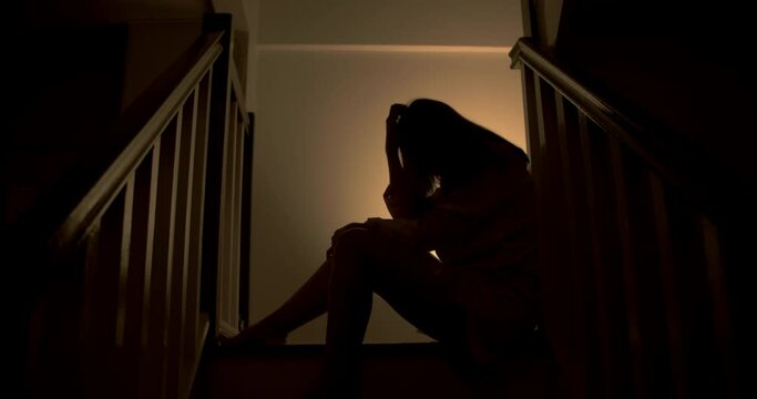A lonely woman is sitting on the stairs at night . This concept use for symptoms of stress, major depressive disorder (MDD), psychotic symptoms.

