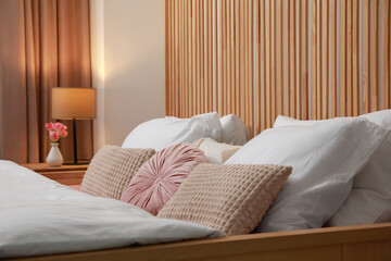 Comfortable bed with cushions in bedroom. Interior design