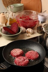 Cooking vegan cutlets in frying pan on stove
